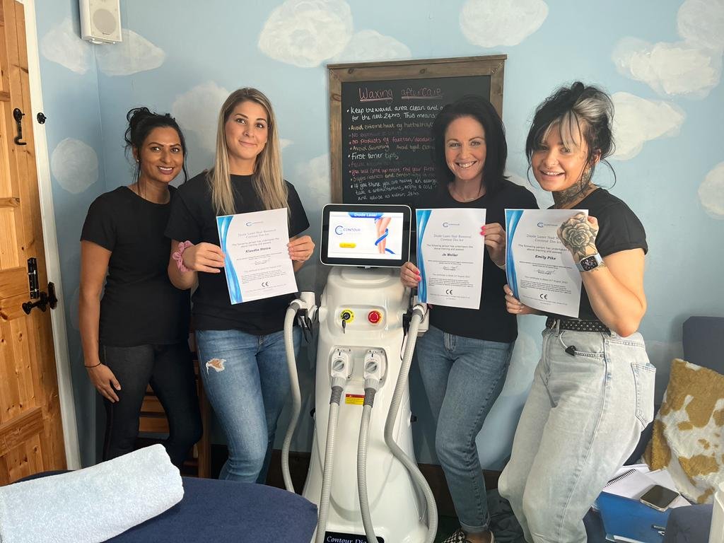 Four practitioners holding diode laser training certificates beside a Contour Dio-Ice machine