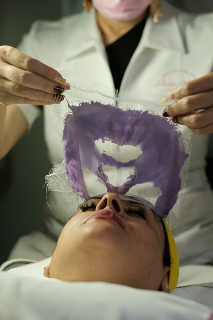 Esthetician removing a facial mask