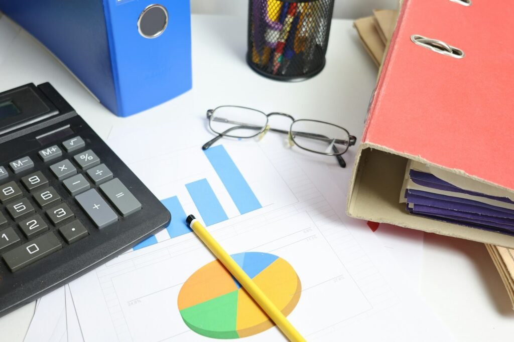 Desk with calculator, charts and binders