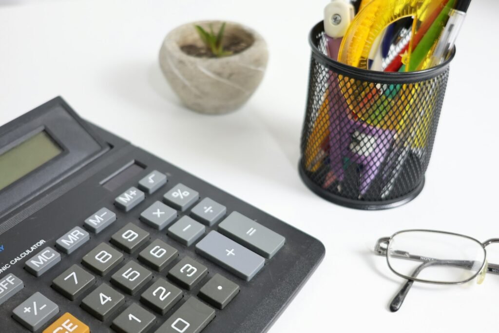 Calculator and glasses on a white desk