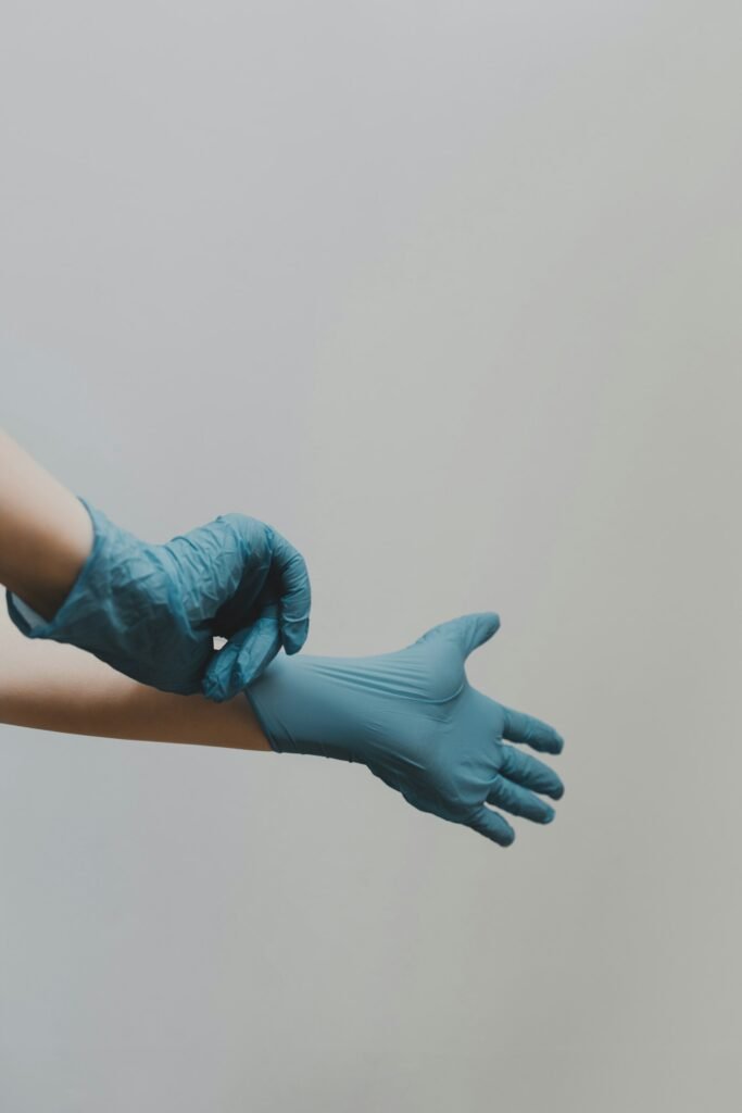 Putting on blue medical gloves